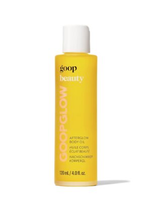 A bottle of goop Beauty Afterglow Body Oil displayed against a backdrop of soft, luxurious fabric. The bottle features a sleek design and clean branding, emphasizing the product's elegance and sophistication."