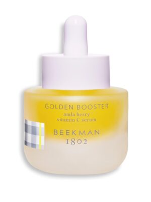 "Image showing Beekman 1802 Golden Booster Amla Berry Face Serum. A luxurious serum bottle with golden accents against a backdrop of fresh Amla berries."