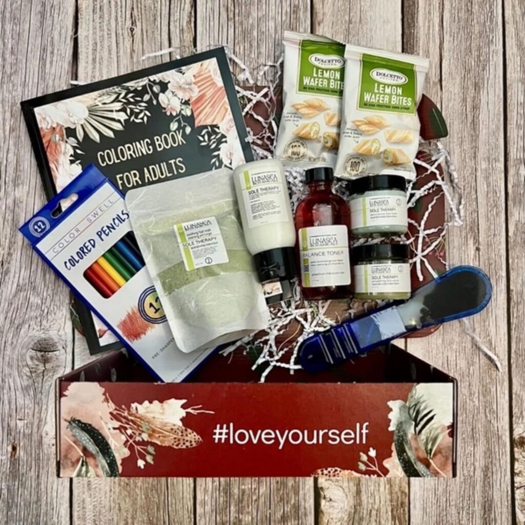 A subscription box for mental wellness, titled "Self-Love in a Box." The box is filled with items aimed at promoting self-care and emotional well-being, including a journal for mindfulness, a candle, a small book on self-love, and a selection of herbal teas. The contents are carefully arranged, evoking a sense of calm and comfort. This mental wellness subscription box provides a soothing experience designed to encourage relaxation, self-reflection, and personal growth.