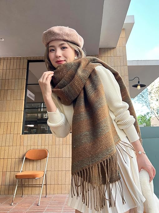 A large, soft pashmina shawl in an brown color, with a cashmere feel. It can be used as a warm scarf in cold weather or as a throw blanket for napping.”