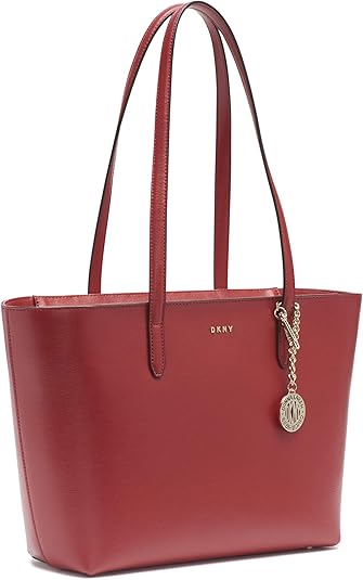 “City chic meets practical elegance with the DKNY Bryant Park Tote. Crafted from high-quality materials, this spacious tote features clean lines, sturdy handles, and subtle branding. Perfect for the modern woman on the move!