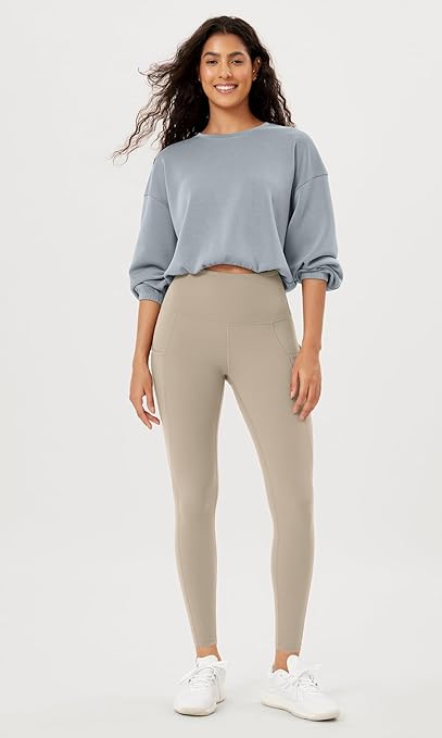 High-waisted yoga leggings for women by ODODOS, featuring pockets and tummy control. These non see-through workout pants are ideal for athletic activities, running, and yoga, offering both comfort and support.